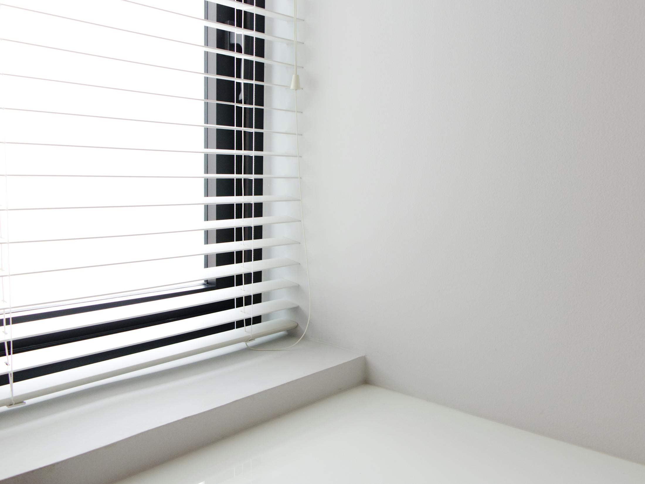 Clean white window blinds in a bright room