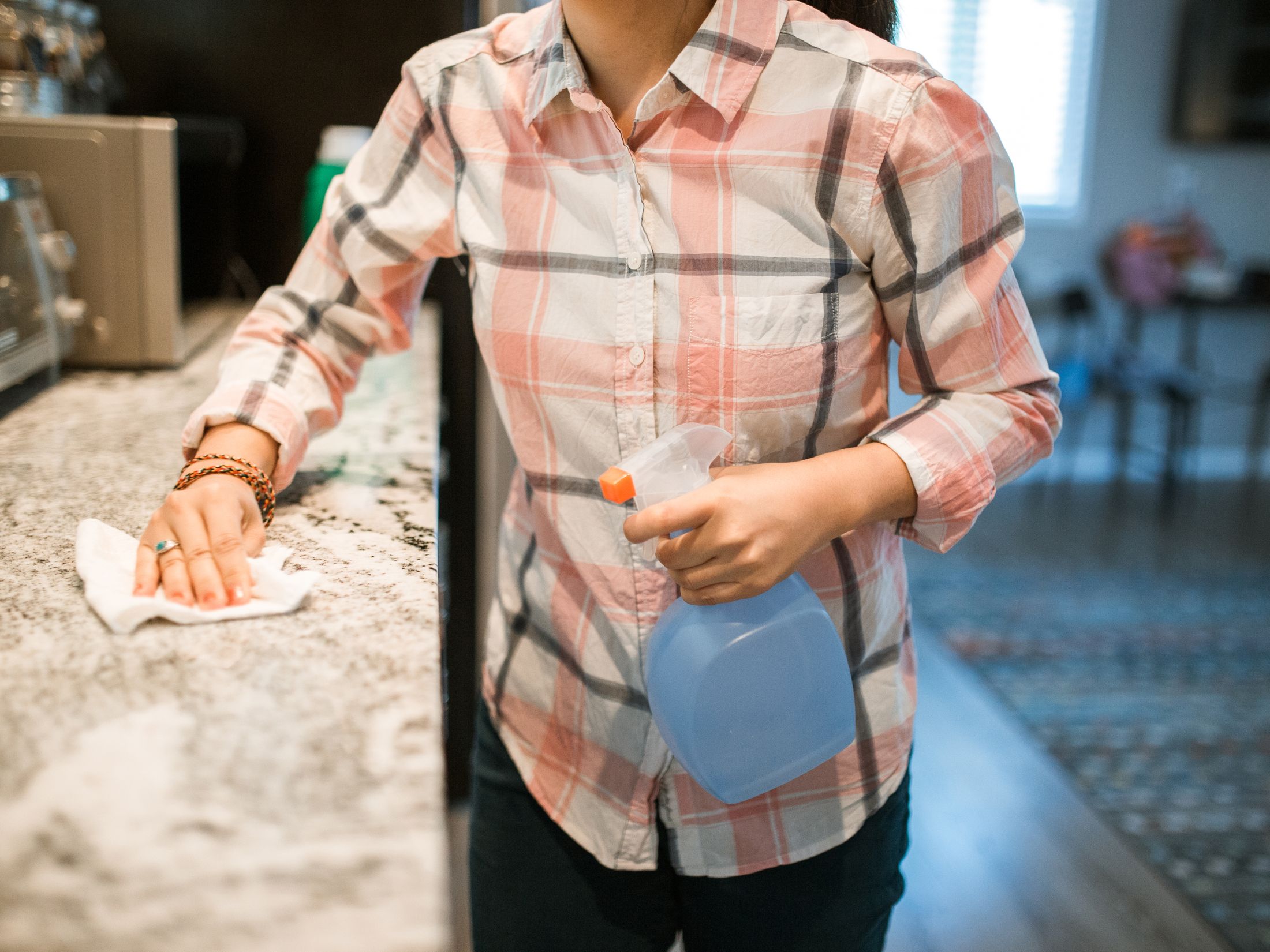 Cleaner wiping down a kitchen counter in a bright Midcoast Maine home