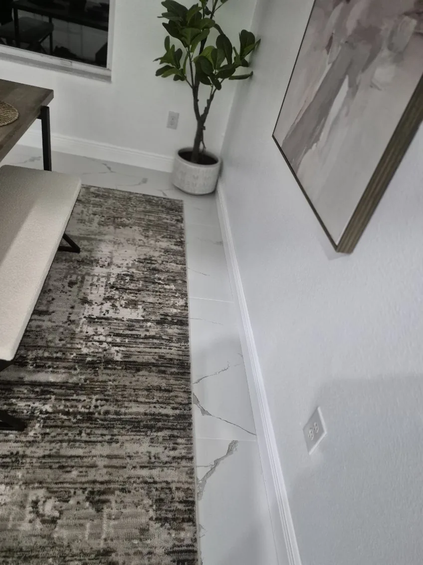 Hallway runner on clean marble floors with spotless baseboards