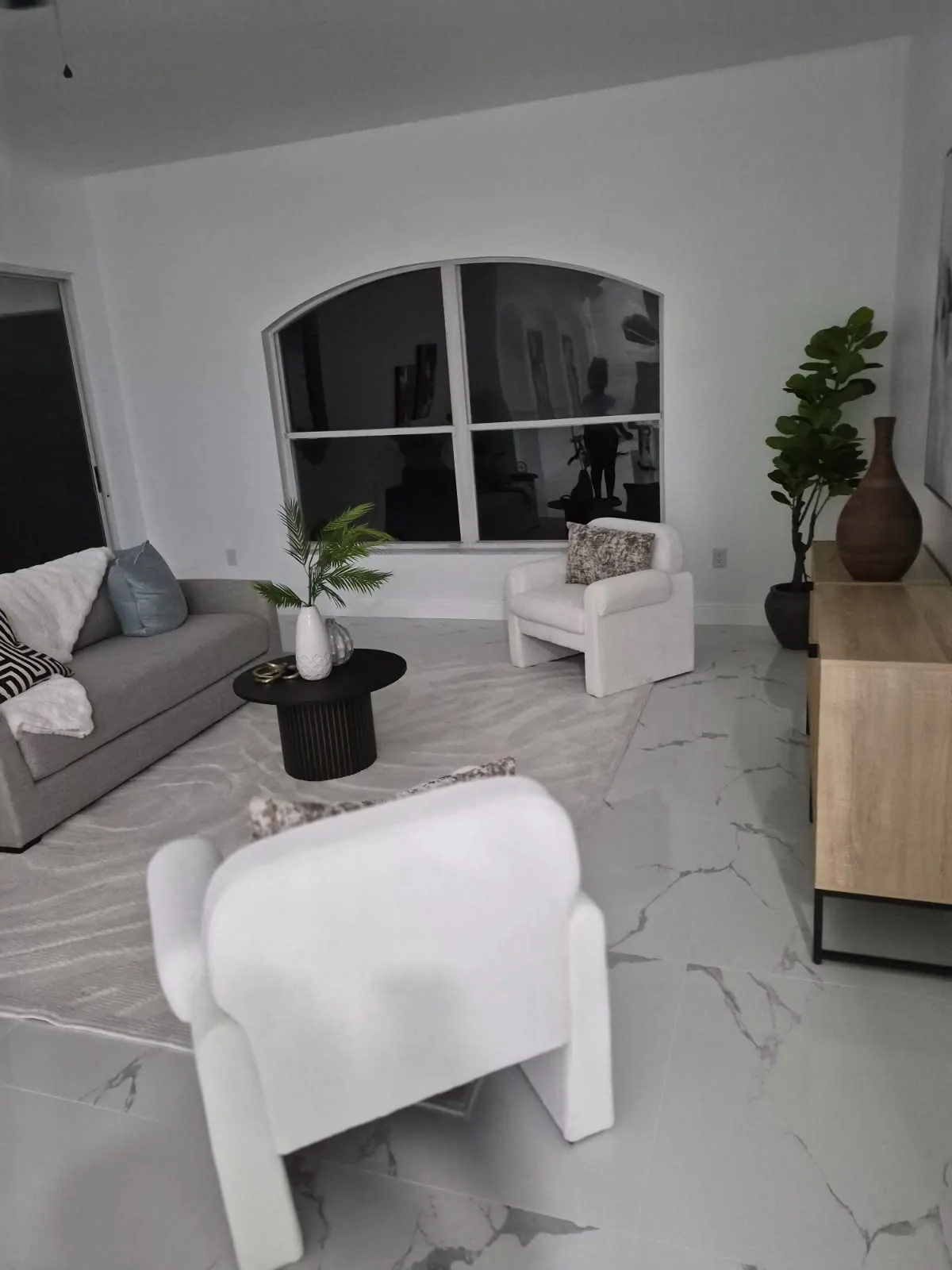 Bright living room with spotless marble floors after a cleaning by Jade's